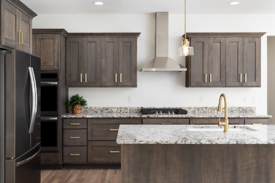 Kitchen remodel in Sacramento — walnut shaker cabinets, granite counters, stainless hood, and brass fixtures