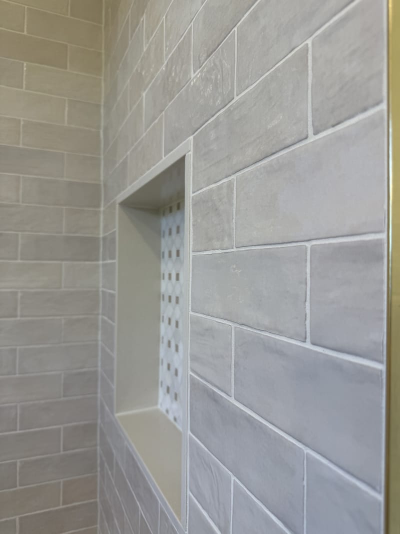 Recessed shower niche with mosaic back and stacked tile surround in a Sacramento bathroom remodel